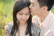 Photo: chinese romantic couple kissing forehead in a park chinese romantic couple kissing forehead in a park