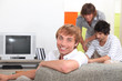 Photo: Three young men about to watch television Three young men about to watch television