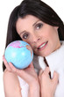 Photo: Brunette holding miniature globe Brunette holding miniature globe