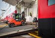 Lift truck unloads big passenger ship through opened side ramp