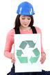 Tradeswoman holding a recycling sign