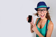 Funny girl with hat and eyeglasses showing smartphone