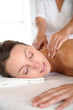 Beautiful girl receiving oil massage in beauty salon