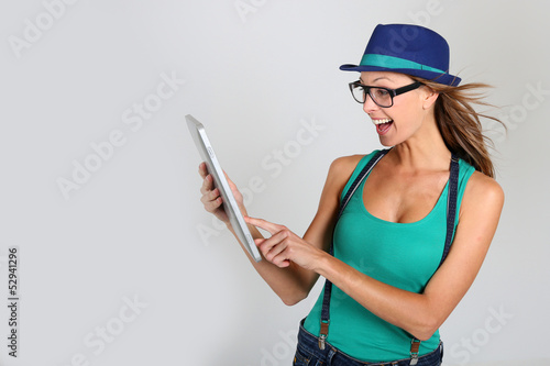Photo: Girl with hat websurfing with tablet Girl with hat websurfing with tablet