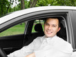 Portrait of young handsome man smiling in his own car