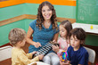 Teacher Playing Xylophone With Students In Preschool