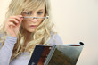Woman with glasses reading magazine