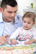Photo: little girl colouring under dad's watchful eye little girl colouring under dad's watchful eye