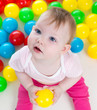 Photo: Top view of baby girl playing with colorful balls Top view of baby girl playing with colorful balls