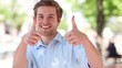 Happy young man showing thumbs up