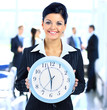 Foto: Young attractive business woman holding clock Young attractive business woman holding clock
