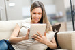 Young woman using a tablet on the sofa