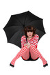 Photo: woman in striped clothing seated on the floor with umbrella woman in striped clothing seated on the floor with umbrella