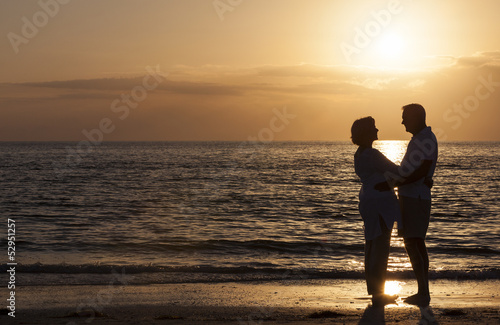 Photo: Happy Senior Couple Embracing on Sunset Beach Happy Senior Couple Embracing on Sunset Beach