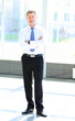 Foto: Full length portrait of a mature business man with hands folded Full length portrait of a mature business man with hands folded