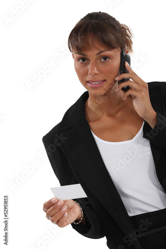 Photo: Woman calling number on business card Woman calling number on business card