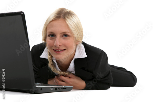 Photo: Blond woman laying with laptop Blond woman laying with laptop