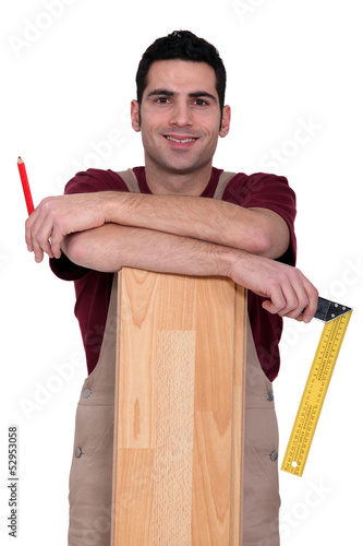 Photo: Worker stood with laminate flooring Worker stood with laminate flooring