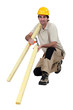 Construction worker holding wooden planks and a hammer
