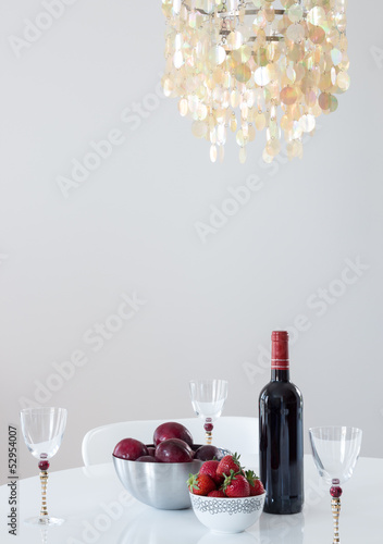 Photo: Red wine with fruits on a table, and beautiful chandelier Red wine with fruits on a table, and beautiful chandelier