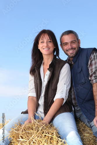 Photo: Couple sitting on haystack Couple sitting on haystack