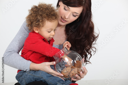 Photo: Little boy grabbing biscuit from jar Little boy grabbing biscuit from jar