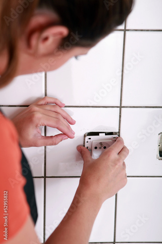 Photo: Female electrician installing a jack Female electrician installing a jack