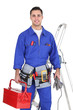 Electrician posing by his equipment