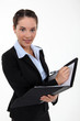 Foto: Beautiful woman holding a clipboard and a pen Beautiful woman holding a clipboard and a pen