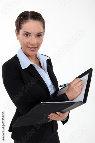 Photo: Beautiful woman holding a clipboard and a pen Beautiful woman holding a clipboard and a pen