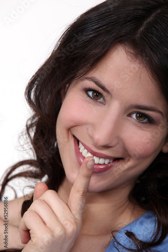 Photo: Smiling woman asking for silence Smiling woman asking for silence