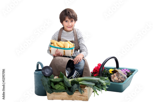 Photo: little boy gathering fresh vegetables in the garden little boy gathering fresh vegetables in the garden
