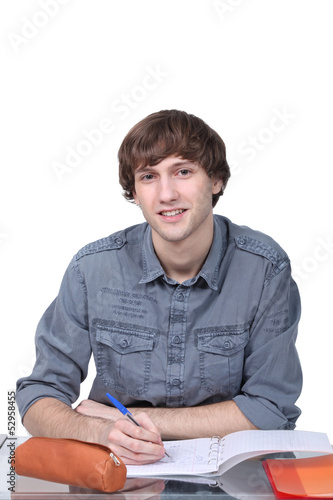 Photo: Young person writing in a workbook Young person writing in a workbook