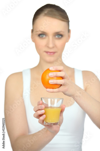 Photo: Woman squeezing fresh orange juice Woman squeezing fresh orange juice