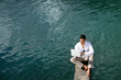 Man siting over water with a laptop