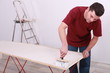 Artisan gluing wallpaper