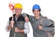 Photo: Experienced tradesman posing with his new apprentice Experienced tradesman posing with his new apprentice