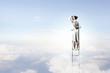 Photo: Businesswoman standing on ladder Businesswoman standing on ladder