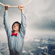Photo: Businessman hanging on rope Businessman hanging on rope