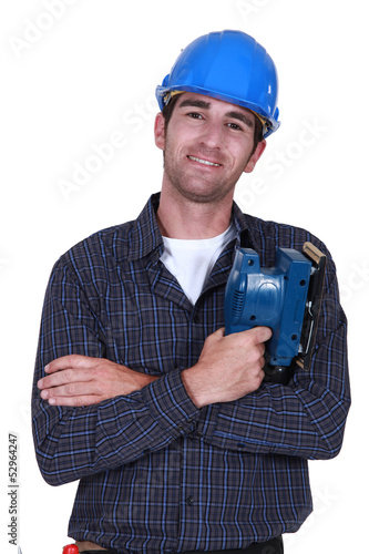 Photo: Man holding electric sander Man holding electric sander