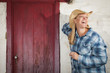 Photo: Beautiful Cowgirl Against Old Wall and Red Door Beautiful Cowgirl Against Old Wall and Red Door
