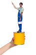 Photo: Male decorator standing on giant paint tin Male decorator standing on giant paint tin