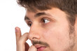 Closeup view of a man's brown eye while inserting a corrective c