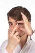 Closeup view of a man's brown eye while inserting a corrective c