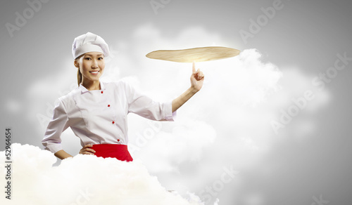 Photo: Asian female cook making pizza Asian female cook making pizza