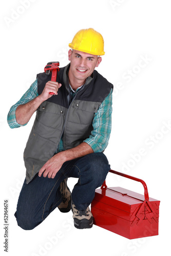 Photo: Smiling plumber with his toolbox on white background Smiling plumber with his toolbox on white background
