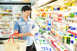 A man buys milk at the supermarket