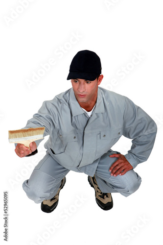 Photo: craftsman painter kneeling and holding a brush craftsman painter kneeling and holding a brush