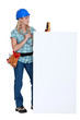 Photo: Female electrician with blank poster Female electrician with blank poster