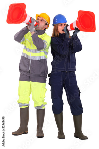 Photo: A team of tradespeople yelling into pylons A team of tradespeople yelling into pylons